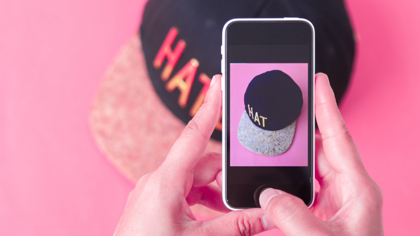 Guy taking a photo of a cap 