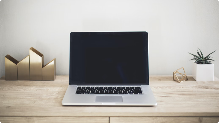 Otvoreni laptop s crnim ekranom na stolu