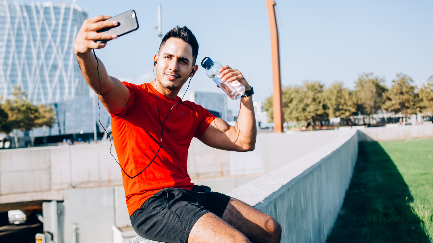 Sport male content creator taking a selfie with a bottle of water